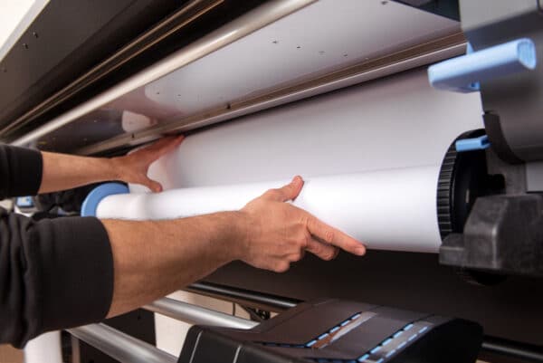 hombre montando rollo de papel en impresora