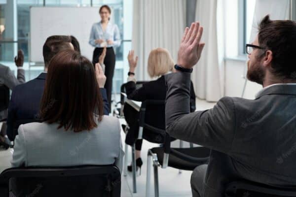 personas levantando la mano para responder preguntas